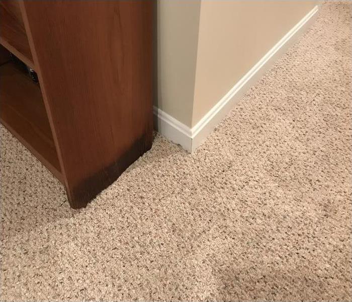 Water damage in a carpet seeping into furniture