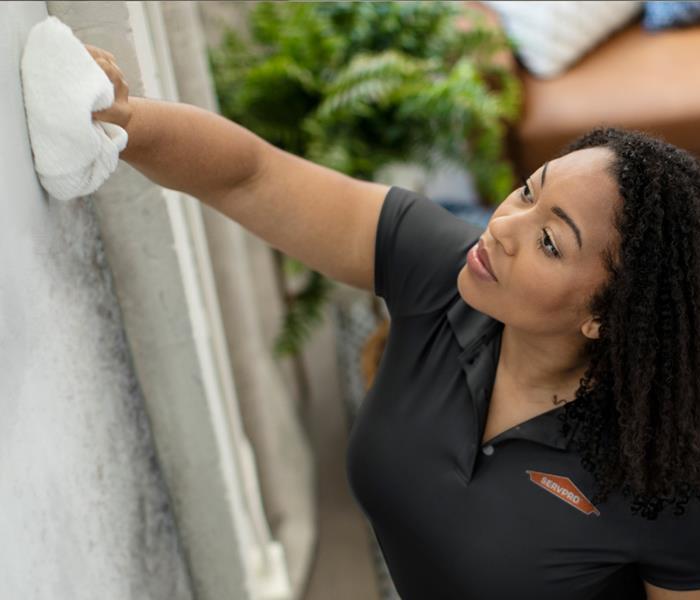 SERVPRO® technician cleaning soot damage from walls